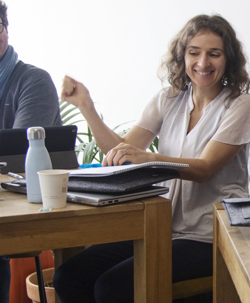 Une participante sereine et souriante, à sa table de travail